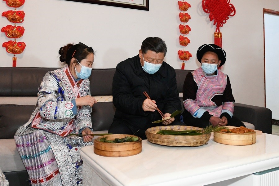 2021年2月3日下午，習(xí)近平在貴州畢節(jié)市黔西縣新仁苗族鄉(xiāng)化屋村苗族村民趙玉學(xué)家，同一家人邊聊家常邊制作當(dāng)?shù)貍鹘y(tǒng)節(jié)日食品黃粑。新華社記者 李學(xué)仁 攝